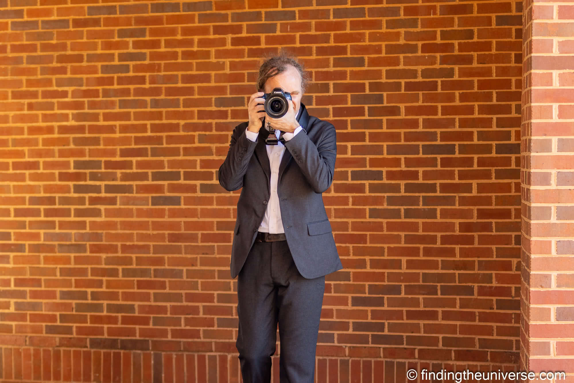 Laurence in suit with camera by Laurence Norah